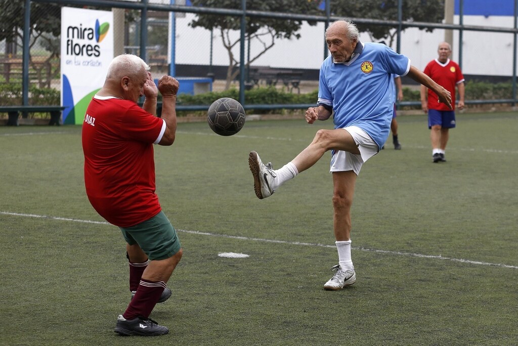 Senior soccer players take part in a match at a soccer field in Miraflores, in Lima, June 19, 2014. Senior players, aged from 60 to 90, play weekly in a program organized by the municipality to promote activities for older adults. Picture taken June 19, 2014. REUTERS/Mariana Bazo (PERU - Tags: SOCIETY SPORT SOCCER TPX IMAGES OF THE DAY) - RTR3VDHD