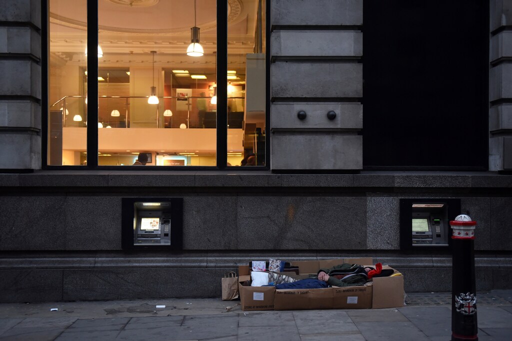 A homeless man sleeps in the cardboard box where he lives, outside Barclays Bank on Fleet Street in London, Britain, December 19, 2017. REUTERS/Mary Turner SEARCH "TURNER HOMELESS" FOR THIS STORY. SEARCH "WIDER IMAGE" FOR ALL STORIES. - RC121BDA1300