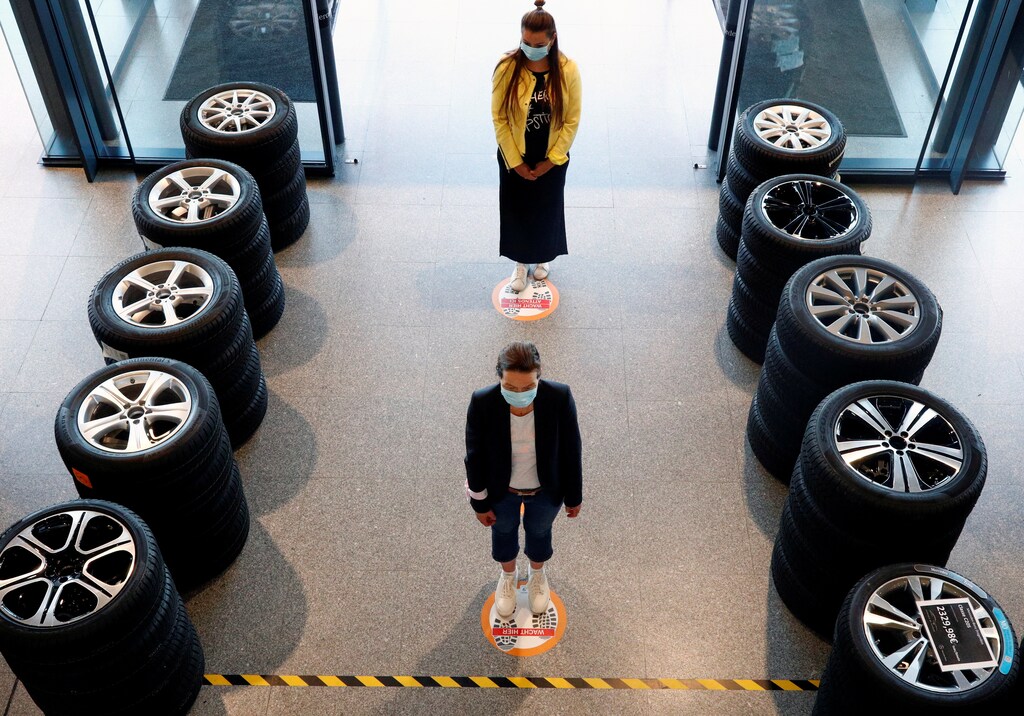 People stand on social-distancing markers at a Mercedes car dealer, as Belgium began easing lockdown restrictions allowing some businesses to reopen, following the coronavirus disease (COVID-19) outbreak, in Brussels, Belgium, May 6, 2020. REUTERS/Francois Lenoir TPX IMAGES OF THE DAY - RC24JG9LRUMI