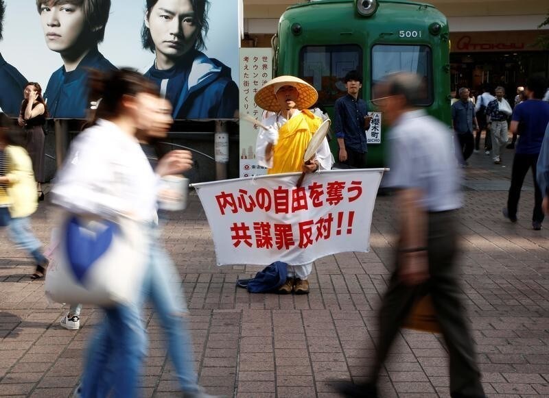 A monk holds a placard with a slogan against a bill targeting conspiracies to commit terrorism and other serious crimes, in front of Shibuya station in Tokyo, Japan June 9, 2017. The slogan reads, "Oppose to conspiracy law which deprives freedom in the mind".