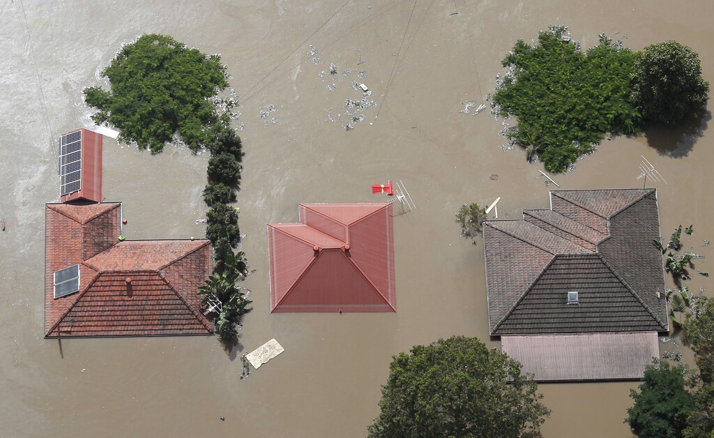 Roofs of houses are visible above flood waters west of Brisbane January 13, 2011. REUTERS/Tim Wimborne (AUSTRALIA - Tags: DISASTER ENVIRONMENT) FOR BEST QUALITY IMAGE: ALSO SEE GM1E7BT12H501. - GM1E71D0TEW01