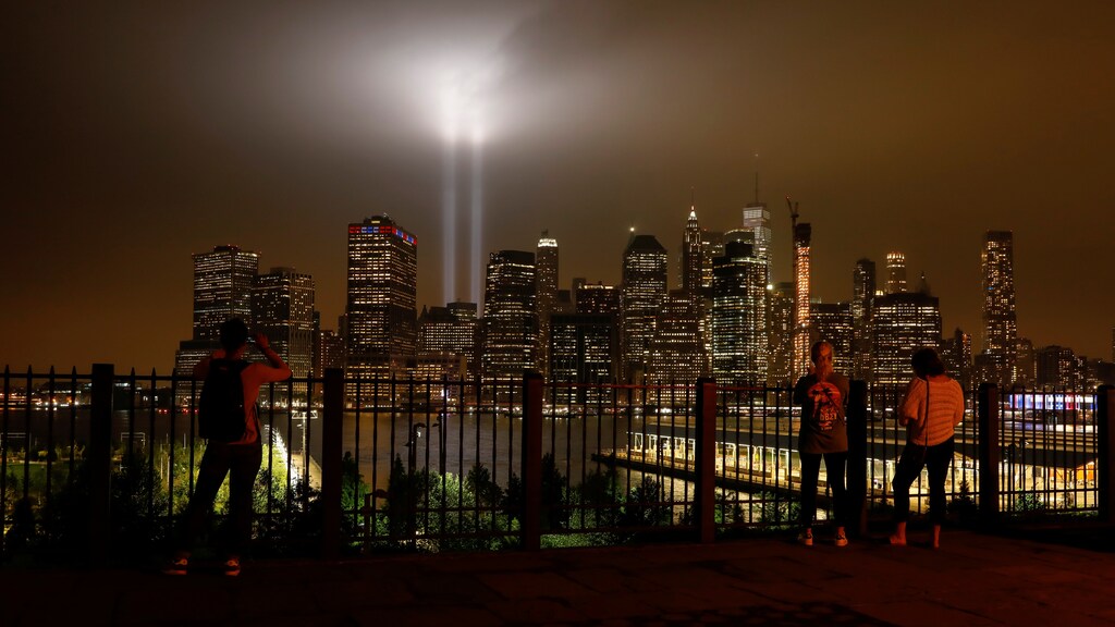 People look at the Tribute in Light installation as it illuminates lower Manhattan as seen from the borough of Brooklyn, marking the 17th anniversary of the 9/11 attacks in New York City, U.S., September 11, 2018. REUTERS/Brendan McDermid