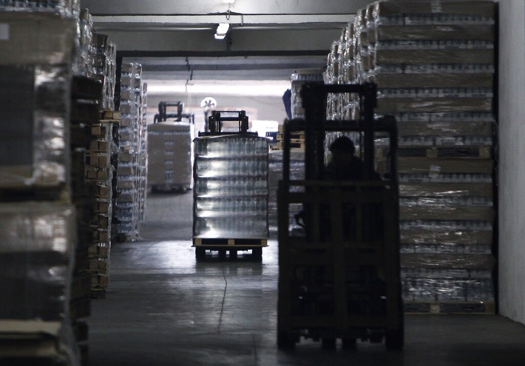 Employees drive forklifts at a warehouse of the IDS Borjomi Georgia's factory in the town of Borjomi, some 150 km (93 miles) southwest of Tbilisi, January 30, 2013. If there's a secret to taking the bitter taste out of ties between Russia and Georgia after a 2008 war, it may lie in this lush valley south of the Caucasus Mountain border between the feuding former Soviet republics. The valley is the source of Borjomi, a salty, sulphurous mineral water that was popular in Russia since Soviet times but was swept off shelves when Moscow banned imports of Georgian beverages in 2006, with tensions already building toward war. Picture taken January 30. To match story GEORGIA-RUSSIA/TALKS