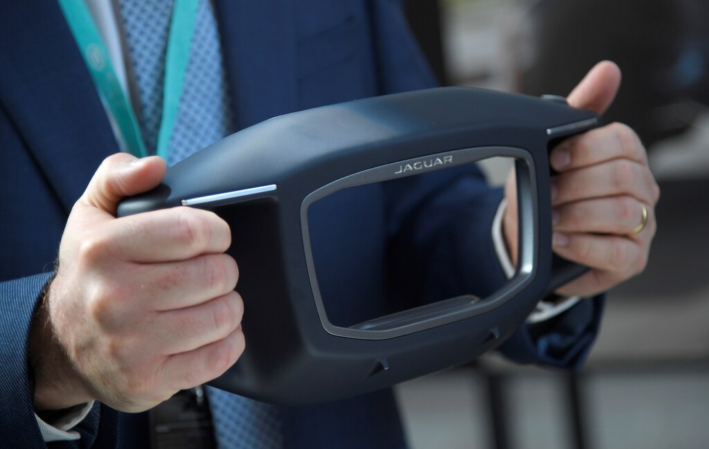 A visitor holds Sayer, a fully voice activated AI concept steering wheel at the Jaguar Land Rover Tech Fest in London in September.