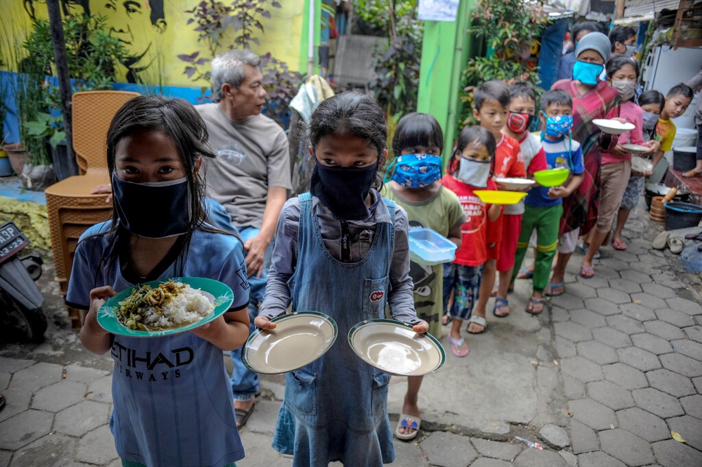 Locals wearing protective masks carry plates while queueing for food distributed for free amid the spread of coronavirus disease (COVID-19) outbreak in Bandung, West Java province, Indonesia, April 10, 2020 in this photo taken by Antara Foto. Antara Foto/Raisan Al Farisi/ via REUTERS ATTENTION EDITORS - THIS IMAGE WAS PROVIDED BY A THIRD PARTY. MANDATORY CREDIT. INDONESIA OUT. - RC2L1G9RXUT8