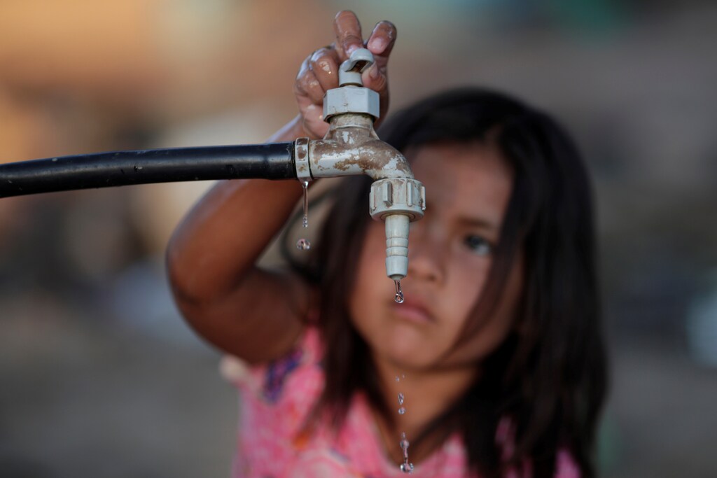 a child turns off a water tap