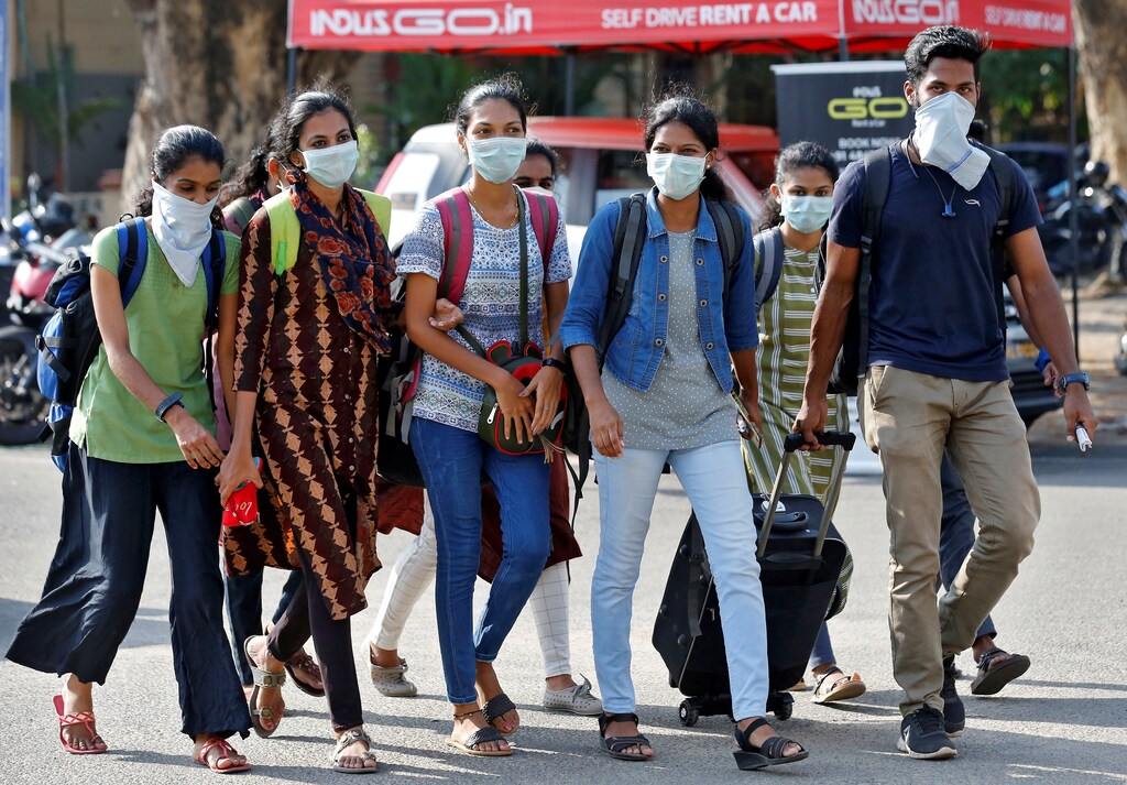 A group of students wearing protective masks walk outside a railway station amid coronavirus fears, in Kochi, India, March 10, 2020. REUTERS/Sivaram V - RC20HF93NFZU
