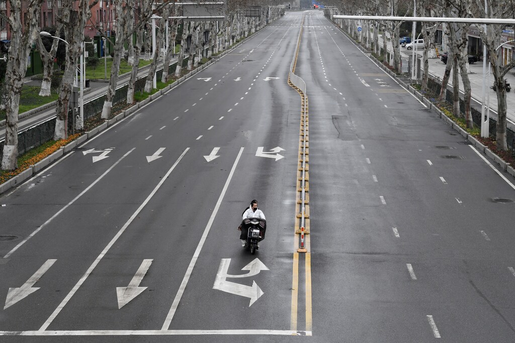 People ride an electric bike on a road in Wuhan, the epicentre of the novel coronavirus outbreak, Hubei province, China March 3, 2020. REUTERS/Stringer CHINA OUT. - RC2DCF9VCWNQ