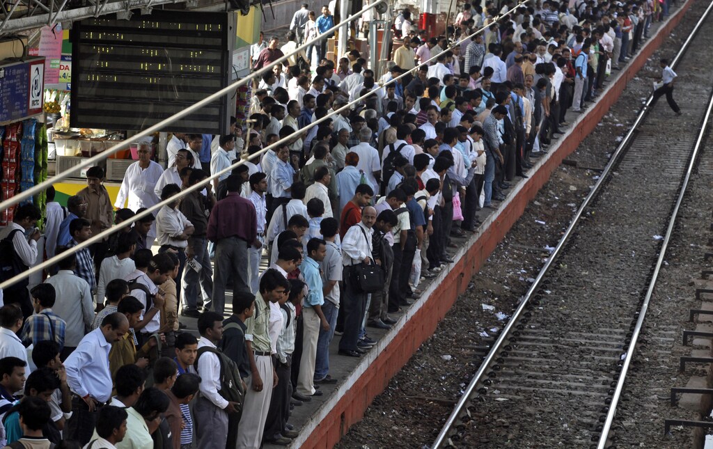 Commuters wait for a train on a crowded railway platform in Mumbai April 1, 2011. India's population grew at its slowest pace since independence in the decade to 2011, the government said on Thursday, a trend welcomed by some since it may lead to higher living standards and sounder public finances in a country with enough young people. REUTERS/Danish Siddiqui (INDIA - Tags: SOCIETY) - RTR2KOAJ