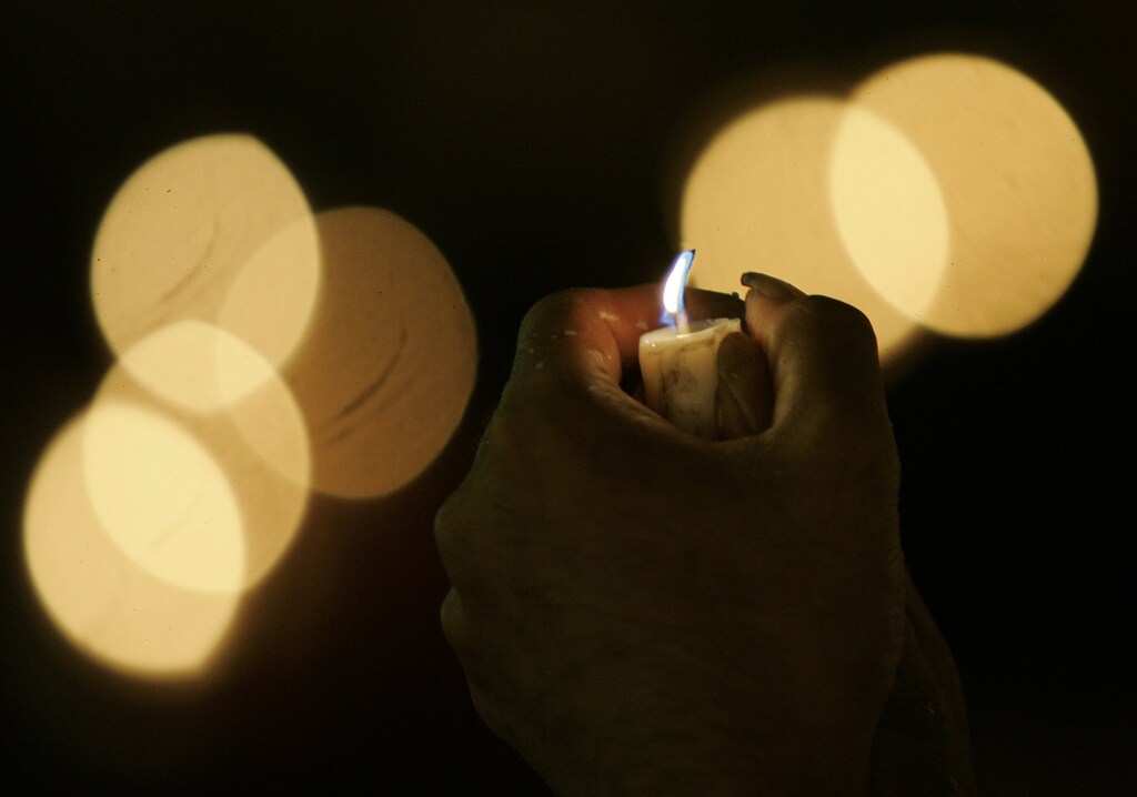 An activist holds a candle during celebrations of the International Day of Peace in Jakarta September 21, 2008. REUTERS/Dadang Tri (INDONESIA) - GM1E49L1U3E01