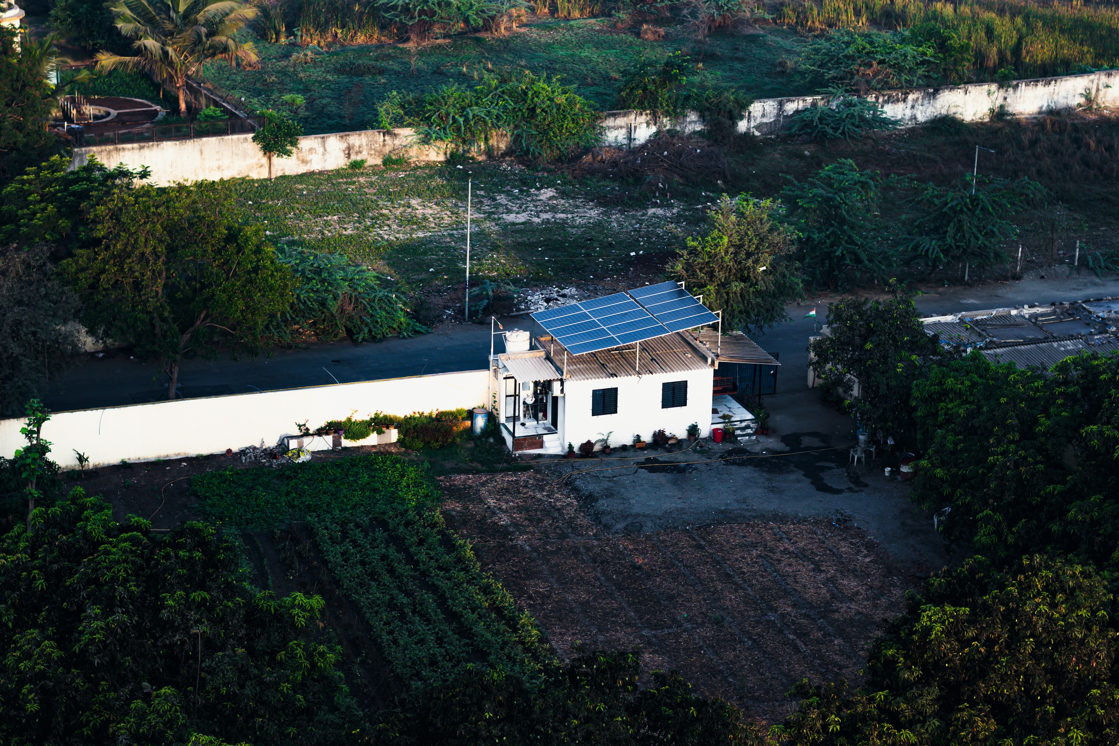 A farmhouse in India with solar panels on its roof generating renewable energy