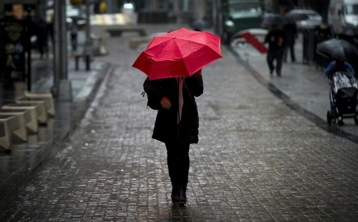 A woman walks on Broad St. past the New York Stock Exchange during the morning commute April 30, 2014. REUTERS/Brendan McDermid (UNITED STATES - Tags: BUSINESS TPX IMAGES OF THE DAY)