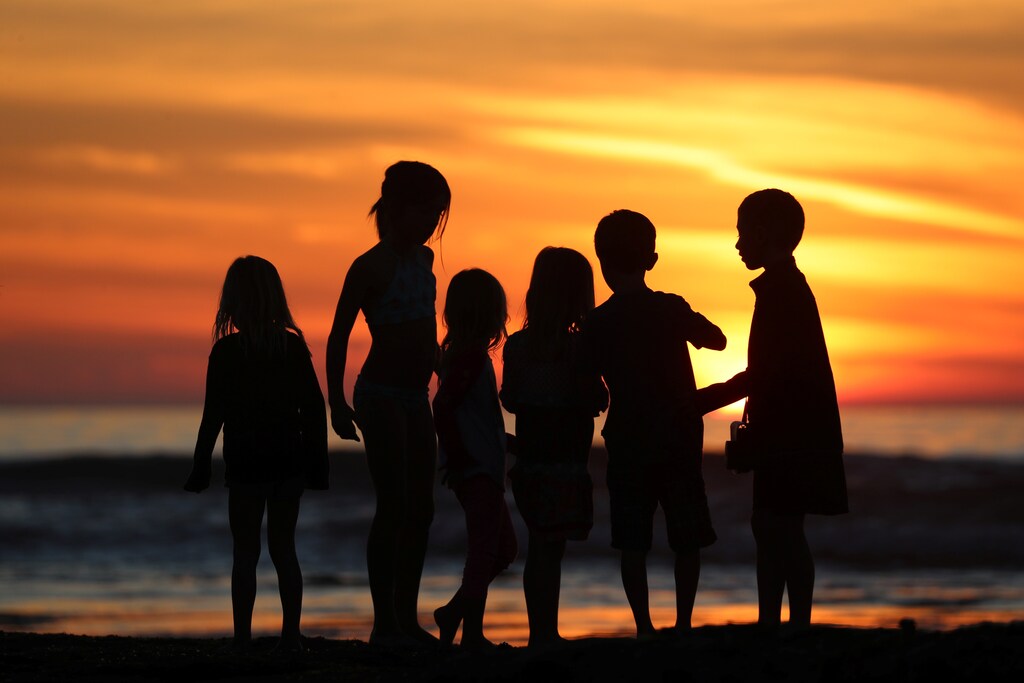 Children watch the sun set as they inspect tide pools during low tide in Solana Beach, California, U.S., January 4, 2018. REUTERS/Mike Blake - RC17C4689E30
