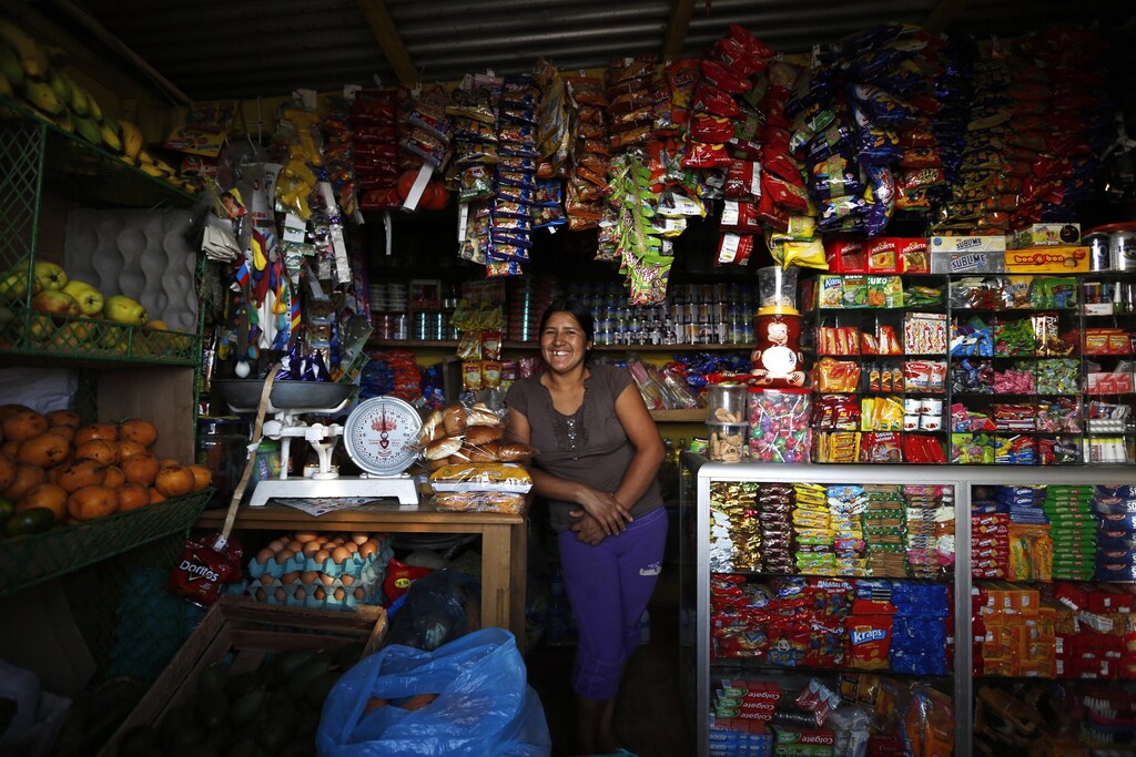 Irma Huaman poses for a photo in her grocery store in Gosen City, a slum in the Villa Maria del Triunfo municipality on the outskirts of Lima March 18, 2014. Huaman arrived in Gosen City 12 years ago when it was just a settlement. She initially worked as a street vendor, until she acquired a loan to build her own store. A number of residents in Gosen City, a slum that grew up near a garbage dump on the outskirts of Lima, have seen their lives improve as parts of Peru feel the effects of years of economic growth. Peru's President Ollanta Humala has pledged to cut poverty to 15 percent by the end of his term in July 2016. He is still a long way from his goal, but the poverty rate is coming down, falling just under two percentage points to 23.9 percent in 2013 from the prior year. Picture taken March 18, 2014. REUTERS/Mariana Bazo (PERU - Tags: BUSINESS POLITICS SOCIETY POVERTY EMPLOYMENT)ATTENTION EDITORS: PICTURE 07 OF 15 FOR PACKAGE 'LIVING THE PERUVIAN DREAM'TO FIND ALL IMAGES SEARCH 'BAZO GOSEN' - Tags: BUSINESS POLITICS SOCIETY POVERTY EMPLOYMENT) - GM1EA6C0KKL01