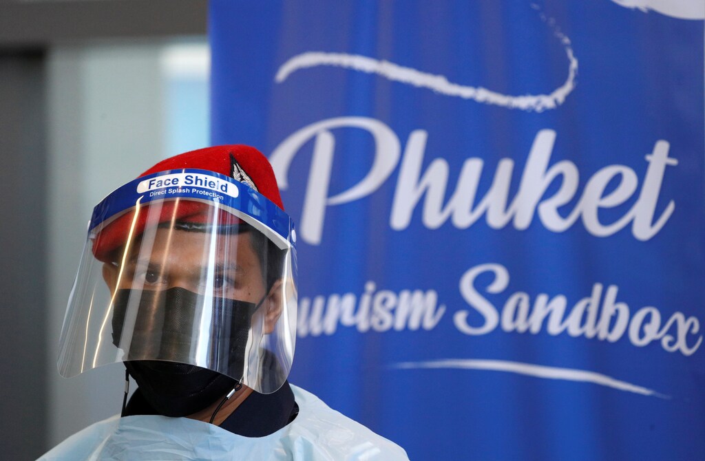 A member of airport security is seen during the arrival of foreign tourists at the airport as Phuket reopens to overseas tourists, allowing foreigners fully vaccinated against the coronavirus disease (COVID-19) to visit the resort island without quarantine, in Phuket, Thailand July 1, 2021. REUTERS/Jorge Silva - RC2FBO99AFHH