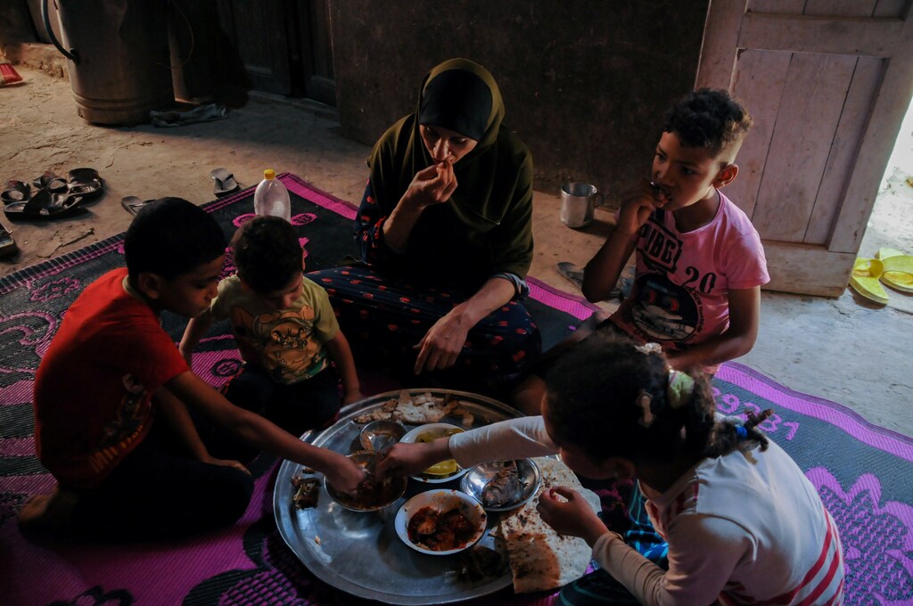 Sabah Khalil, 37, eats with her children at home in al-Aalam village in Fayoum, Egypt, June 29, 2021. Picture taken June 29, 2021. REUTERS/Rania Gomaa