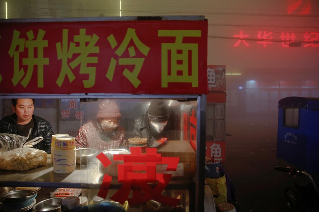 Street food vendors work as heavy smog blankets Shengfang, in Hebei province, on an extremely polluted day with red alert issued, China December 19, 2016. REUTERS/Damir Sagolj - RTX2VOP5