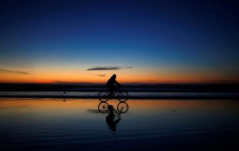 A youth rides a bicyle on a beach at the border between U.S. and Mexico, in Tijuana, Mexico December 8, 2018. REUTERS/Mohammed Salem - RC17CDE54530
