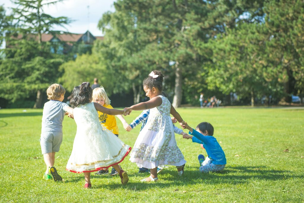Niños jugando y bailando en círculo.