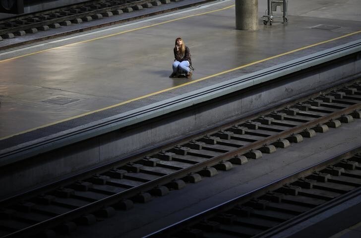 A woman sits on her suitcase as she waits for a train during a 24-hour nationwide train strike against the privatization plans of railways public companies Adif and Renfe at Santa Just train station in the Andalusian capital of Seville, southern Spain October 31, 2013. REUTERS/Marcelo del Pozo (SPAIN - Tags: BUSINESS CIVIL UNREST EMPLOYMENT TRANSPORT TPX IMAGES OF THE DAY)