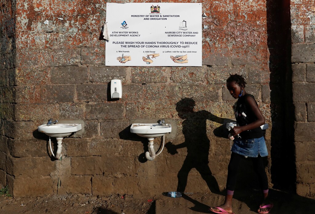 A girl walks past taps allocated for sanitization.
