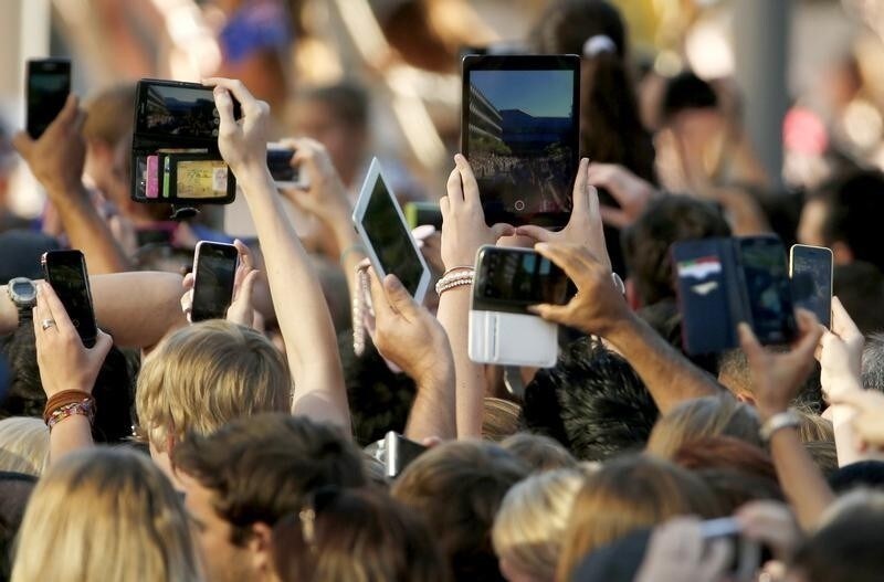 Members of the public use their mobile devices to take photographs of Britain's Prince William and his wife Catherine, Duchess of Cambridge at a walk about in Brisbane, April 19, 2014. Britain's Prince William and his wife Kate are on the second leg of a 19 day official visit to New Zealand and Australia with their son George. REUTERS/Phil Noble (AUSTRALIA - Tags: ROYALS POLITICS ENTERTAINMENT TPX IMAGES OF THE DAY) - RTR3LVTI