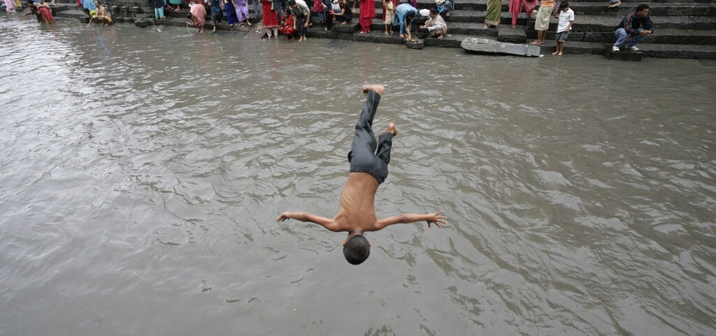 A Hindu boy dives into Bagmati River after a solar eclipse in Kathmandu July 22, 2009. As heatwaves grip swathes of South Asia and the US, it is essential that response plans like that of Nepal are developed.