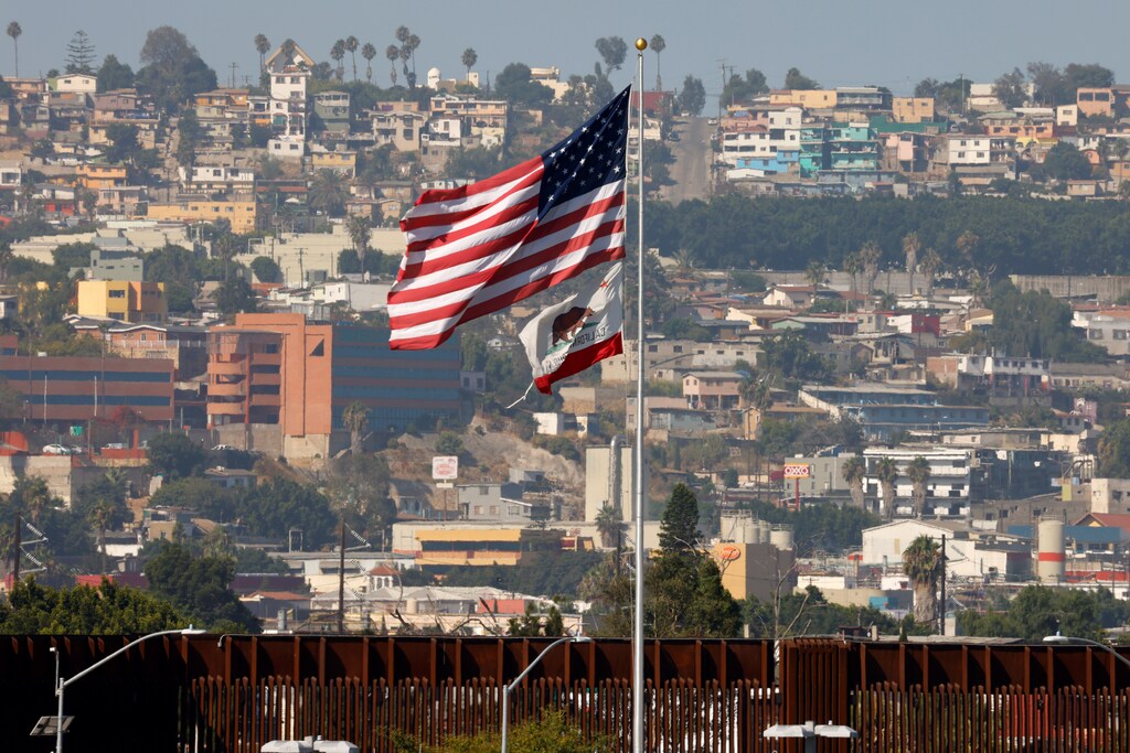 The state flag of California and the U.S. flag fly next to the border wall near Tijuana, Mexico, and during the outbreak of coronavirus disease (COVID-19), in San Diego, California, U.S., August 14, 2020. REUTERS/Mike Blake - RC2WDI95XDYW