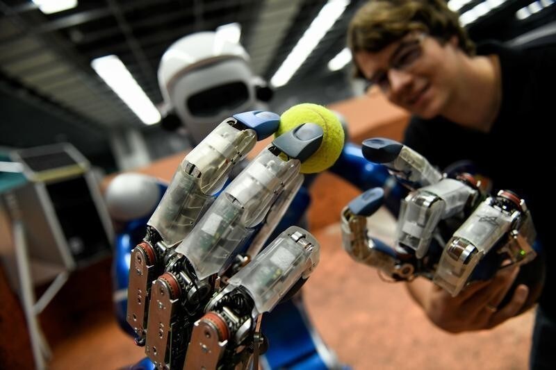 Humanoid robot Justin holds a tennis ball in a laboratory at the German Aerospace Center (DLR) in Wessling, near Munich, Germany, October 4, 2018. Picture taken October 4, 2018.