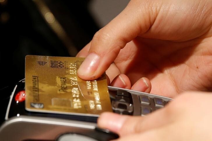 A customer pays with a contactless credit card at a store in Paris, France, April 11, 2016. REUTERS/Philippe Wojazer