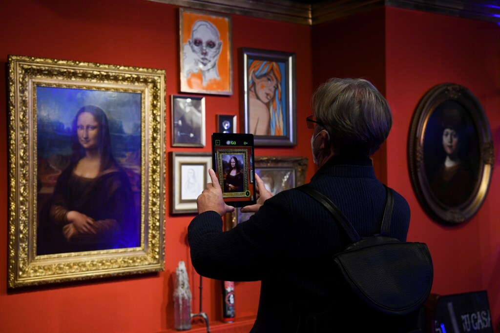 A visitor with tablet computer is pictured during a tour through the urban NFT LAB called "GAME OVER" by the artist group Die Dixons