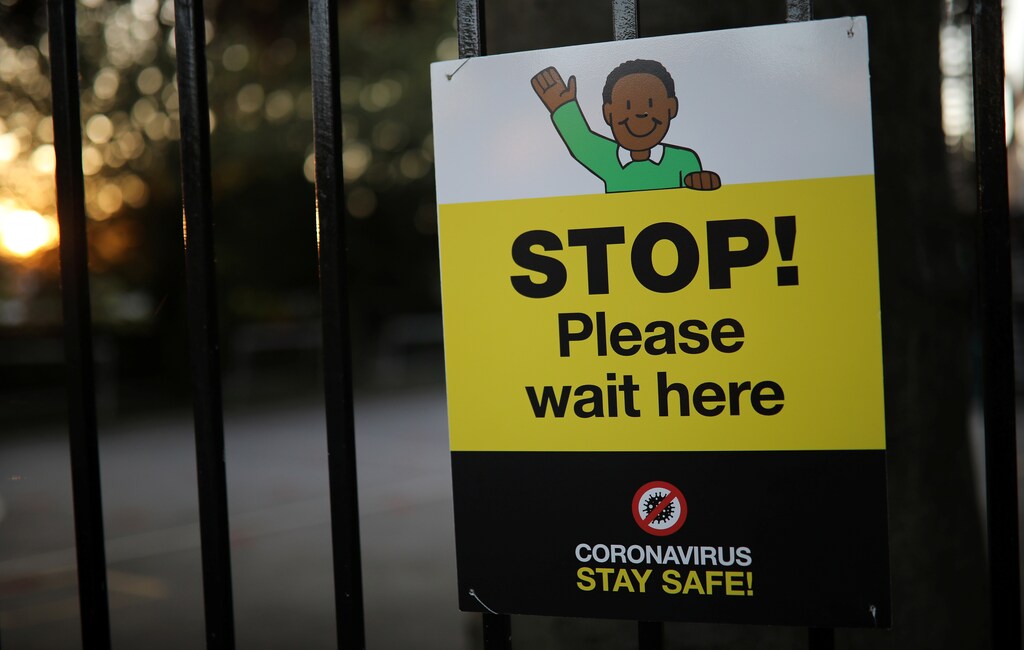A social distancing sign is seen on the gate of a school as the spread of the coronavirus disease (COVID-19) continues in Hale, Britain, May 31, 2020. REUTERS/Phil Noble - RC2WZG94T40Y