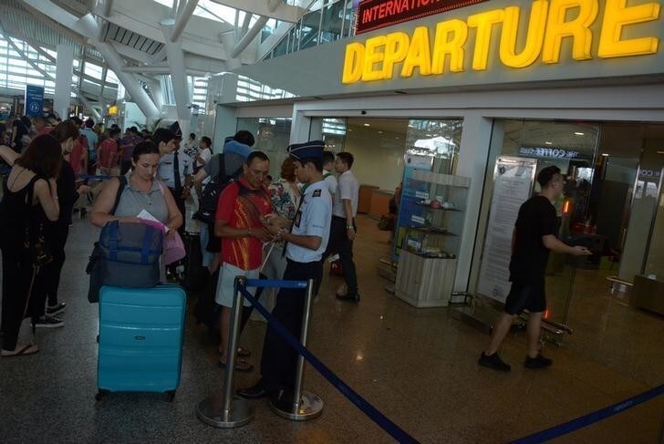 Passengers line up to enter the departure terminal Officers at Ngurah Rai Airport after it reopened following Mount Agung volcano's eruption on the holiday island in Kuta, Bali, Indonesia November 29, 2017 in this photo taken by Antara Foto. Antara Foto/Wira Suryantala/ via REUTERS ATTENTION EDITORS - THIS IMAGE WAS PROVIDED BY A THIRD PARTY. MANDATORY CREDIT. INDONESIA OUT.