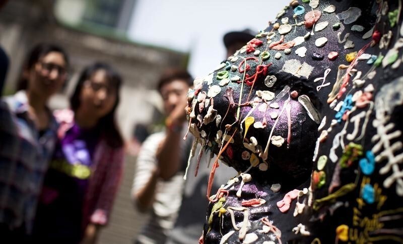 Students inspect artist Douglas Coupland's "Gumhead" sculpture outside of the Vancouver Art Gallery in downtown Vancouver June 11, 2014. Coupland invites people to stick chewing gum on the resin and polyester sculpture, which depicts his own head. Picture taken June 11, 2014.