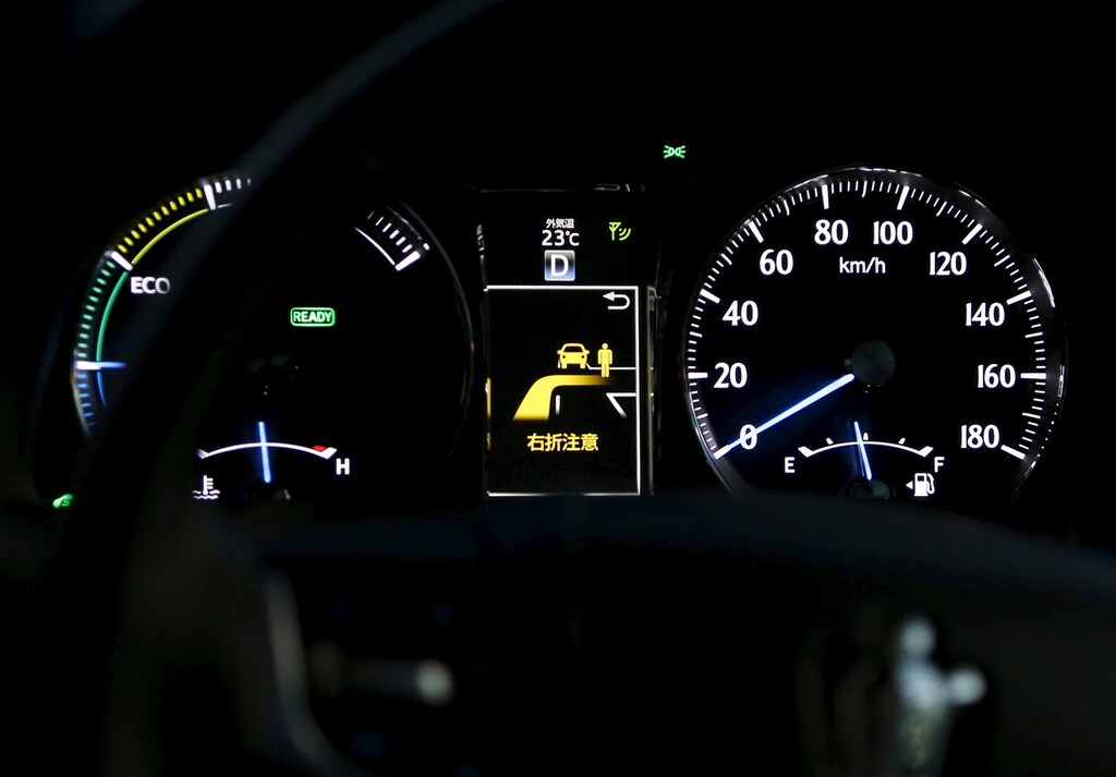 An onboard display between speed meters shows a right turn collision caution as a staff member of Toyota Motor Corp drives its latest model of Toyota Crown equipped with the "intelligent transportation system" (ITS) technology, which allows vehicle-to-infrastructure communication to alert drivers of dangers, during the Toyota Advanced Technologies media preview in Tokyo, Japan, October 8, 2015. Toyota Motor Corp said it would aim to bring to market cars that can autonomously change lanes, merge with traffic, and overtake other vehicles on highways by around 2020 as it aims to catch up in the nascent field of self-driving cars. REUTERS/Yuya Shino - GF10000236544