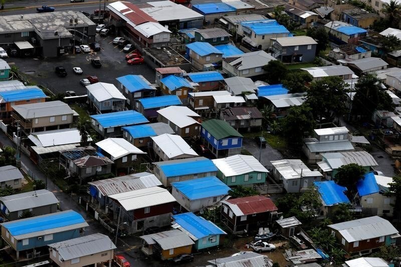 Plastic tarps over damaged roofs are seen on houses a year after Hurricane Maria devastated Puerto Rico in San Juan, Puerto Rico, September 18, 2018. Picture taken September 18, 2018. REUTERS/Carlos Barria - RC17278135F0