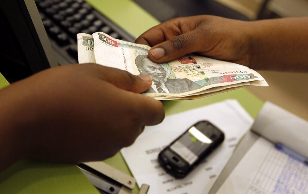 A customer conducts a mobile money transfer, known as M-Pesa, inside the Safaricom mobile phone care centre in the central business district of Kenya's capital Nairobi July 15, 2013. Picture taken July 15. REUTERS/Thomas Mukoya (KENYA - Tags: BUSINESS TELECOMS) - GM1E99J0R5W01