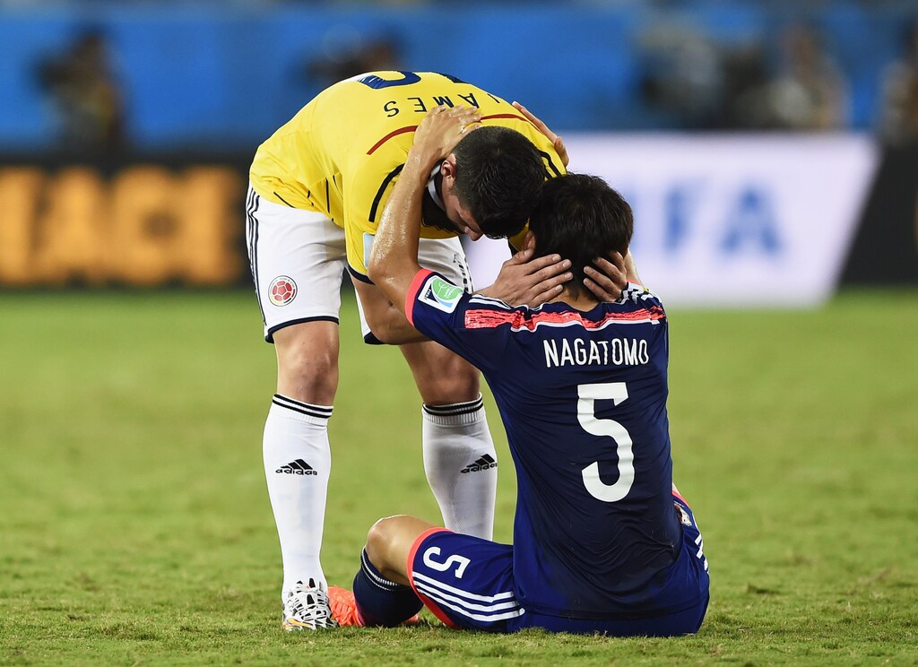 Colombia's James Rodriguez (L) greets Japan's Yuto Nagatomo after Colombia won their 2014 World Cup Group C soccer match at the Pantanal arena in Cuiaba June 24, 2014. REUTERS/Dylan Martinez (BRAZIL - Tags: SOCCER SPORT WORLD CUP) - TB3EA6O1PIKUR