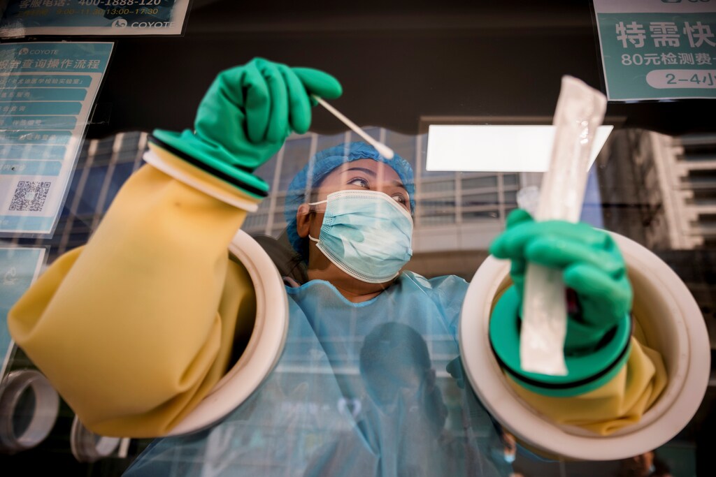 A medical staff administers a nucleic acid test at a booth on a street in Beijing, China, as outbreaks of the coronavirus disease (COVID-19) continue, October 20, 2021. REUTERS/Thomas Peter