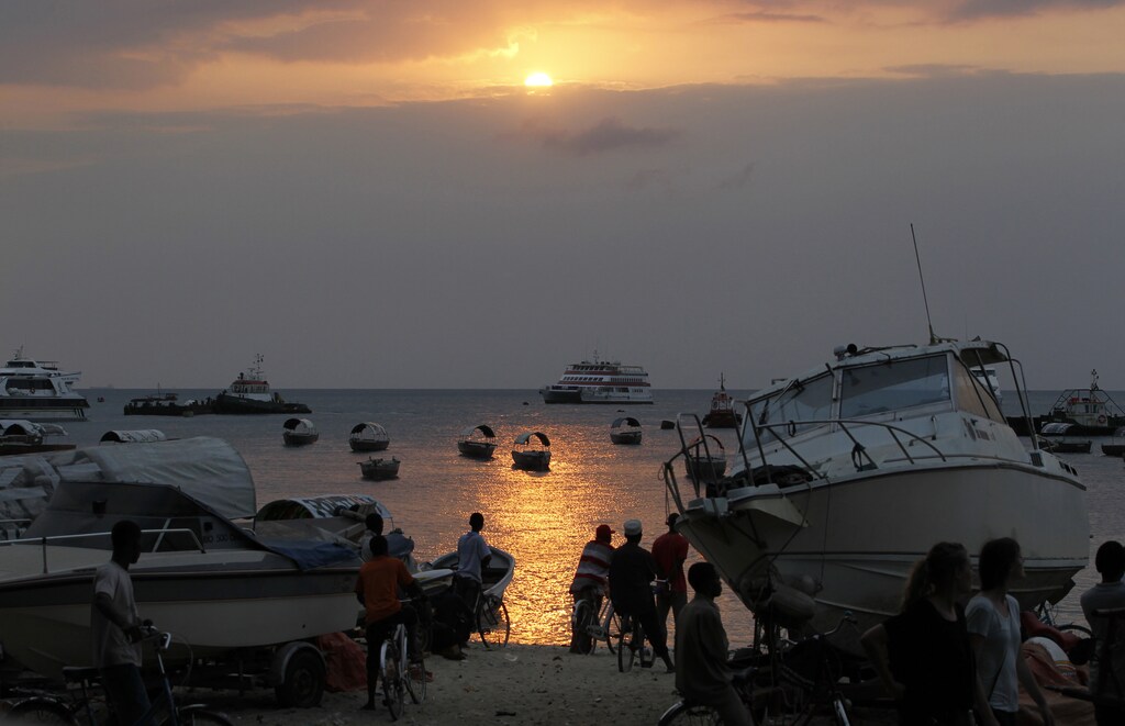 Residents rest along the beach during sunset near the Port of Zanzibar on the island of Zanzibar July 19, 2012. Rescue workers fought rough seas on Thursday to search for more than 100 people missing after an overcrowded ferry sank near the Indian Ocean archipelago of Zanzibar, but hopes of finding survivors were slim. At least 38 people, including an American citizen, were confirmed dead and 145 were rescued after the MV Skagit/Kalama passenger boat capsized on Wednesday around midday near Chumbe island, west of Zanzibar. REUTERS/Thomas Mukoya