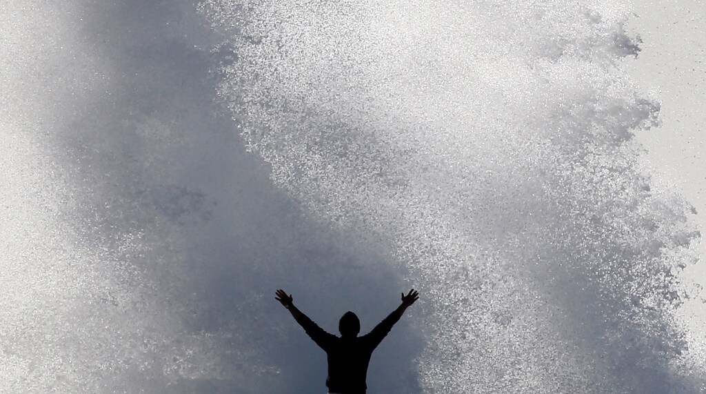 A passer-by watches high waves hitting the waterfront in Marseille, France, November 13, 2017. REUTERS/Jean-Paul Pelissier - RC12FA772740