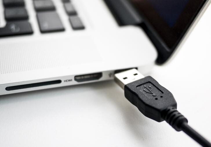A photo illustration shows a USB device being plugged into a laptop computer in Berlin July 31, 2014. USB devices such as mice, keyboards and thumb-drives can be used to hack into personal computers in a potential new class of attacks that evade all known security protections, German crypto specialist and chief scientist with Berlin's SR Labs Karsten Nohl revealed on Thursday. REUTERS/Thomas Peter (GERMANY - Tags: CRIME SCIENCE TECHNOLOGY)