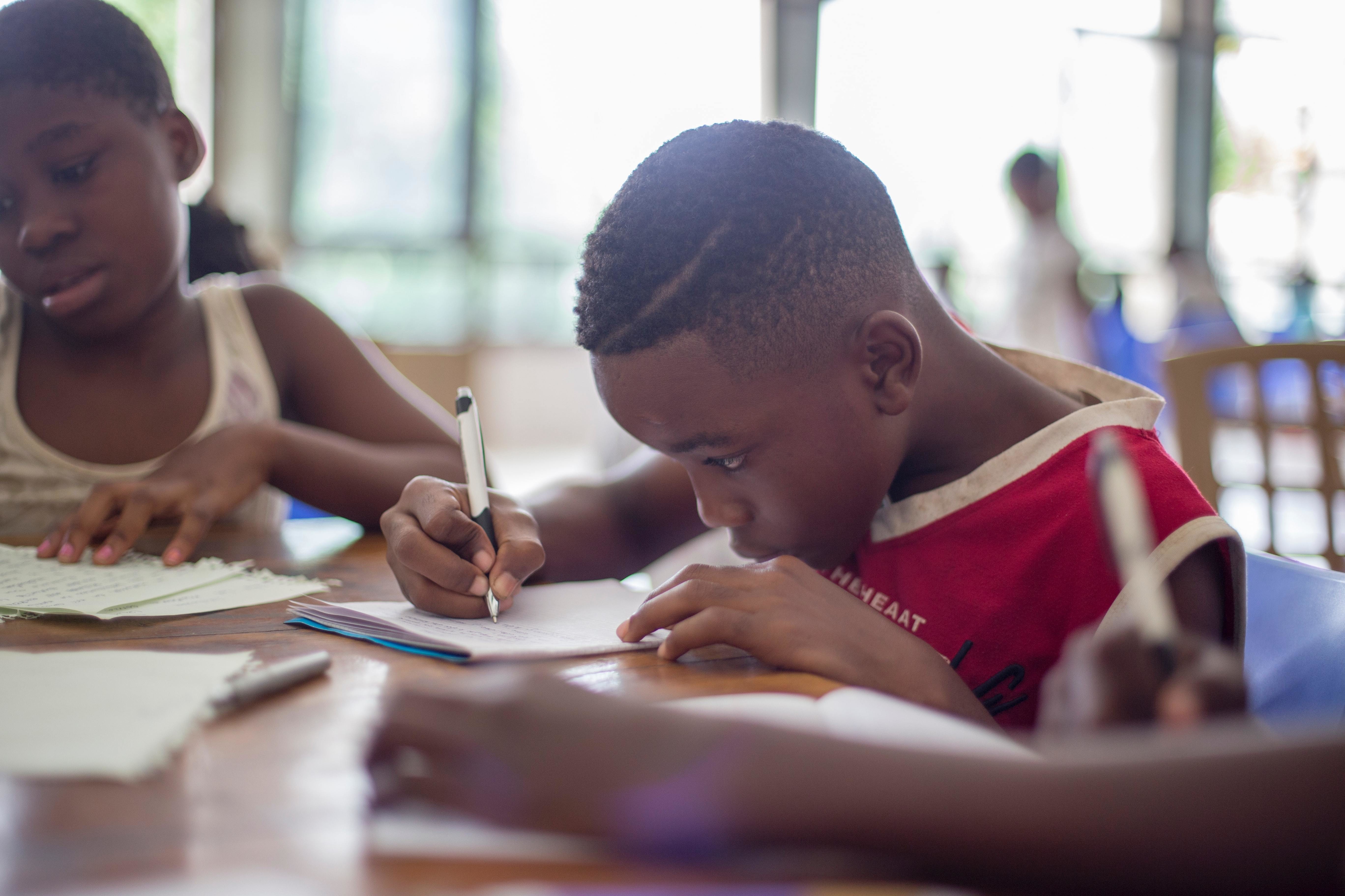 Child writing in a notebook.