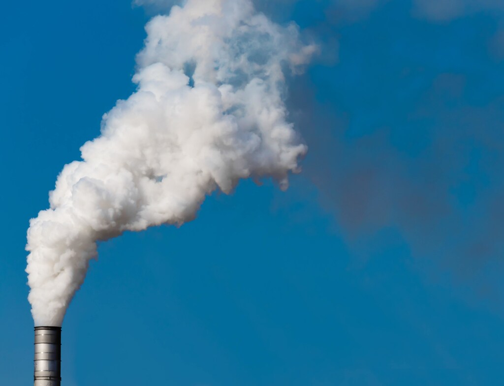 Pictured is a factory chimney emitting smoke.