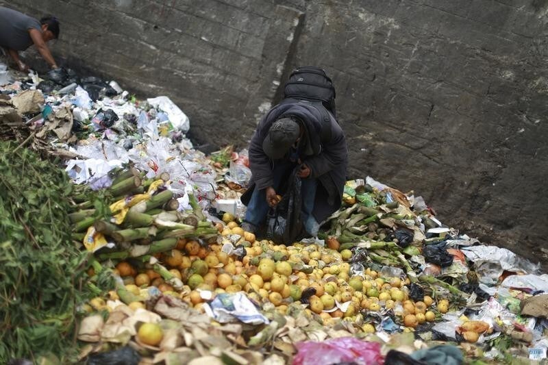 A man picks up oranges at the garbage dump of the La Terminal food centre, one of the largest food markets in Guatemala City February 27, 2015. REUTERS/Jorge Dan Lopez (GUATEMALA - Tags: SOCIETY FOOD) - GM1EB2S0S9701