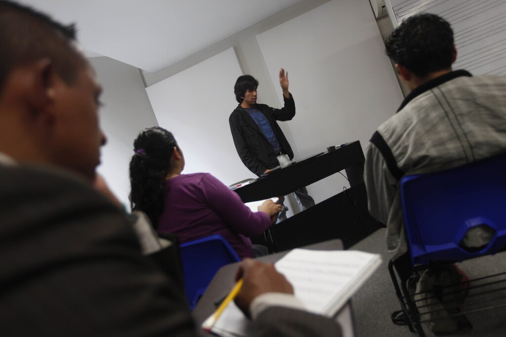 A teacher conducts a musical introduction lesson to students during a class at the school of Maricahi Ollin Yoliztli in Mexico City October 17, 2012. The school of Maricahi Ollin Yoliztli will be the first to award a professional degree for mariachi music in Mexico. The degree program takes 3 years to complete and classes began on October 15 with 106 students enrolled, according to Leticia Soto, director of the school of Marciachi Ollin Yoliztli. REUTERS/Edgard Garrido (MEXICO - Tags: SOCIETY EDUCATION) - RTR399H4