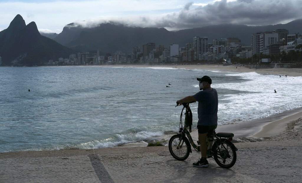 A man wearing a protective mask observes the Arpoador beach during the coronavirus disease (COVID-19) outbreak, in Rio de Janeiro, Brazil, March 29, 2020. REUTERS/Ricardo Moraes TPX IMAGES OF THE DAY - RC2WTF97YZ6V