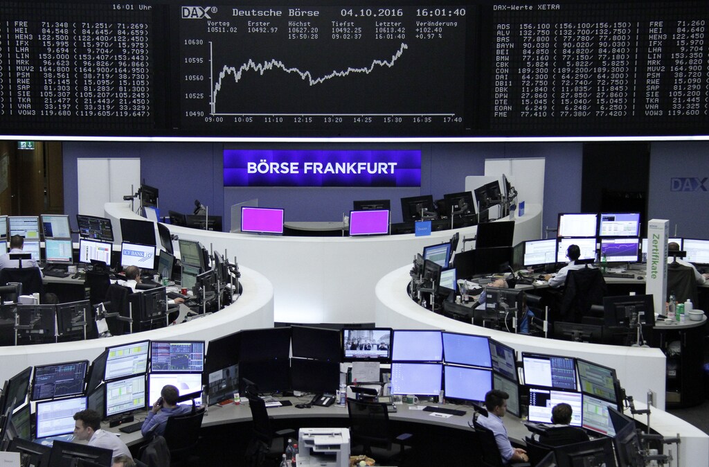 Traders work at their desks in front of the German share price index, DAX board, at the stock exchange in Frankfurt, Germany, October 4, 2016. REUTERS/Staff/Remote - RTSQPMX
