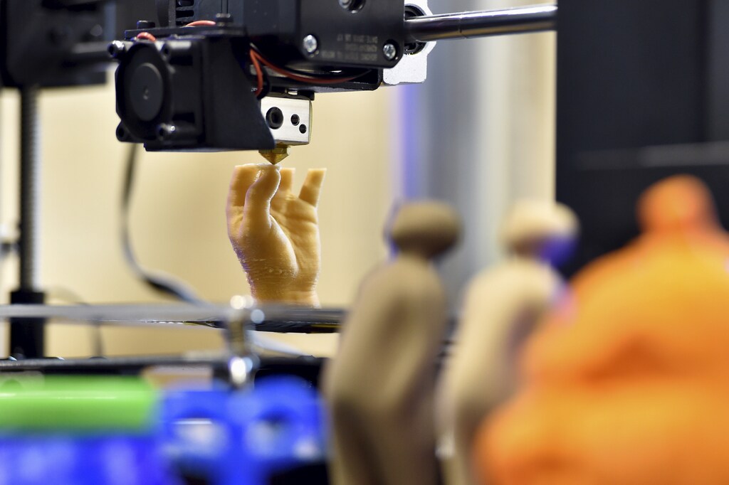 3D printed objects are displayed as an artificial hand is being printed during a 3D printing show in Brussels, Belgium, October 18, 2015.