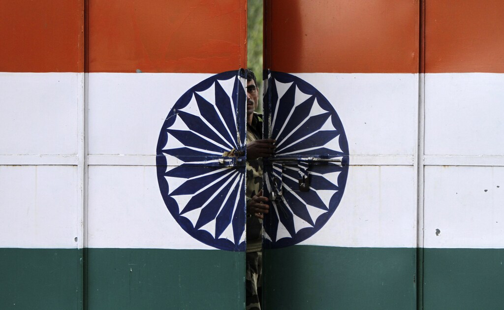 An Indian Border Security Force (BSF) soldier opens a gate at the border with Pakistan in Suchetgarh, southwest of Jammu, January 12, 2013. At least four soldiers, two each from India and Pakistan, have been killed in clashes since last Sunday in disputed Kashmir, where the nuclear-armed enemies are separated by a Line of Control (LoC) set up in 1948. REUTERS/Mukesh Gupta (INDIAN-ADMINISTERED KASHMIR - Tags: MILITARY POLITICS) - GM1E91D0CXJ01